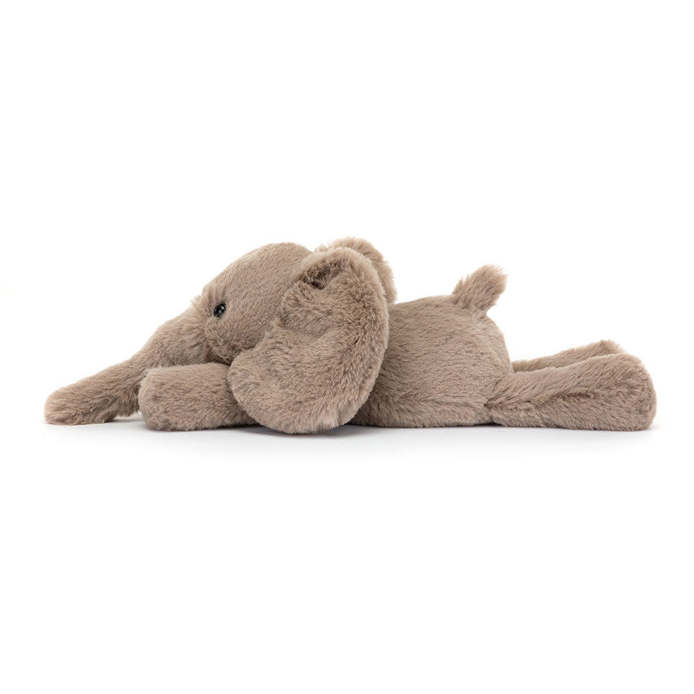 A side photo of a tiny sized plush toy elephant with soft grey-brown fur, big black eyes, and large ears.