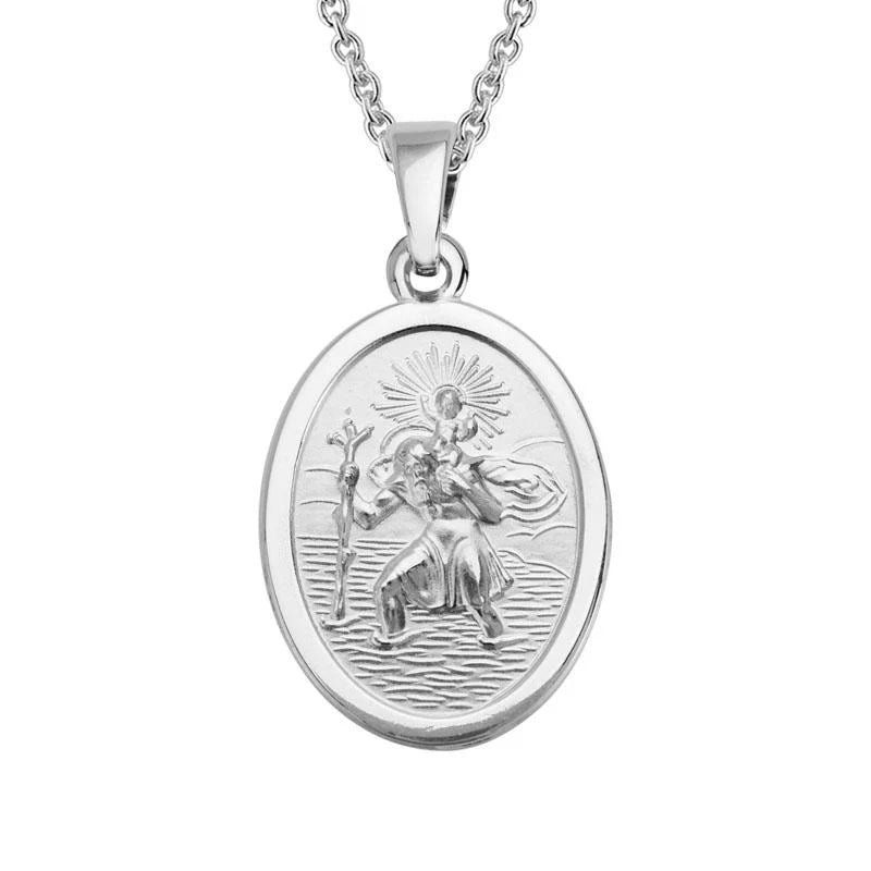 A silver oval religious pendant necklace featuring an embossed figure, suspended from a matching silver chain against a plain white background.