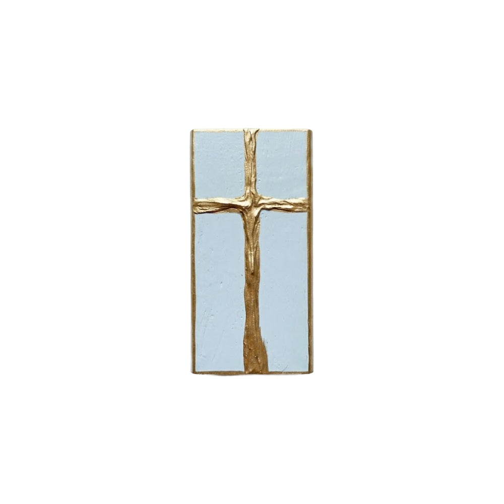 Gold cross decorative light blue painted wooden block on a white background