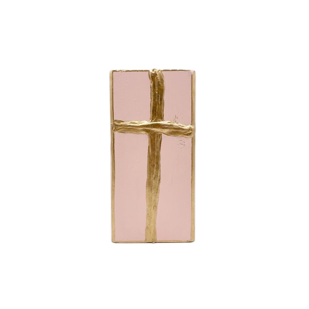 Gold cross decorative pink painted wooden block on a white background