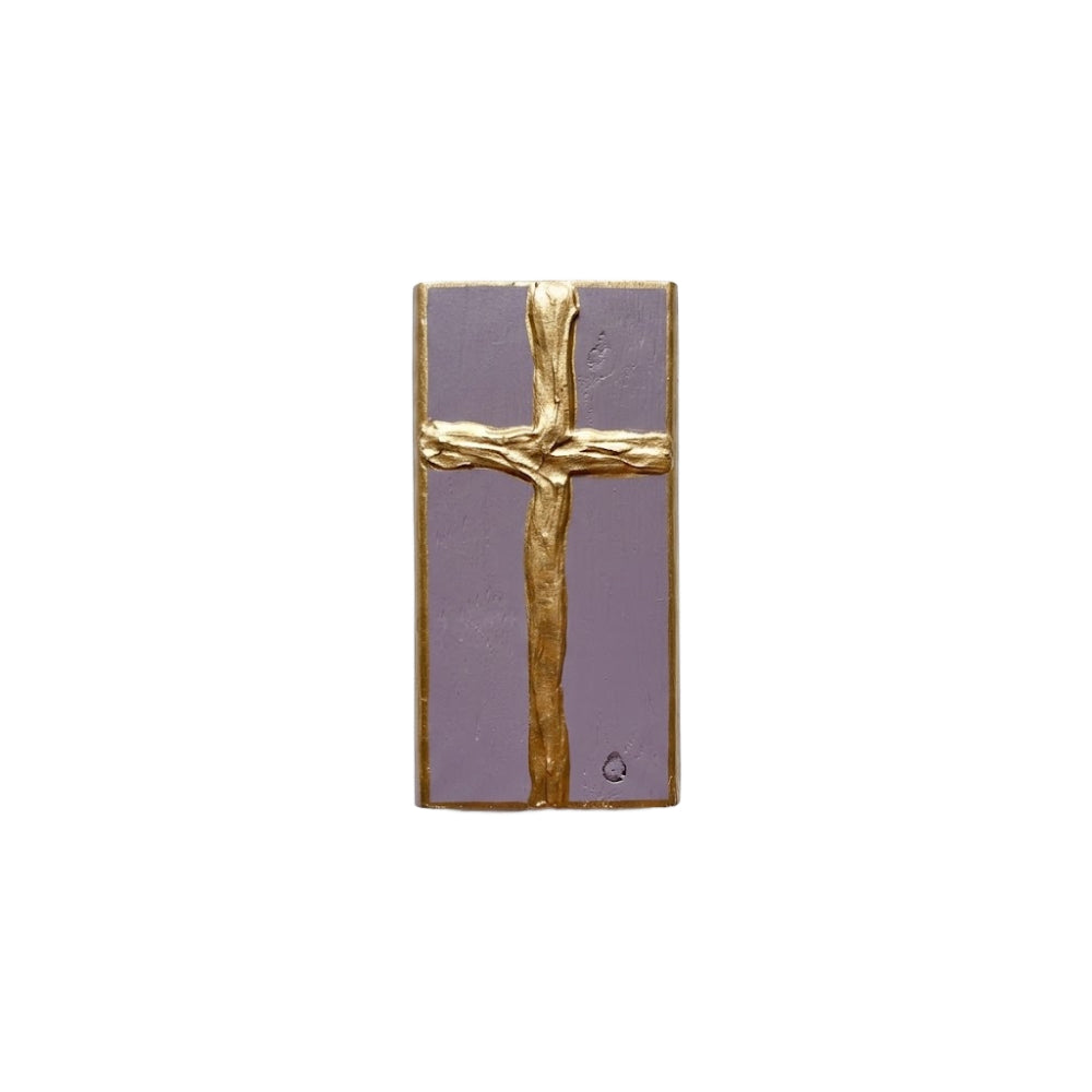 Gold cross decorative purple painted wooden block on a white background