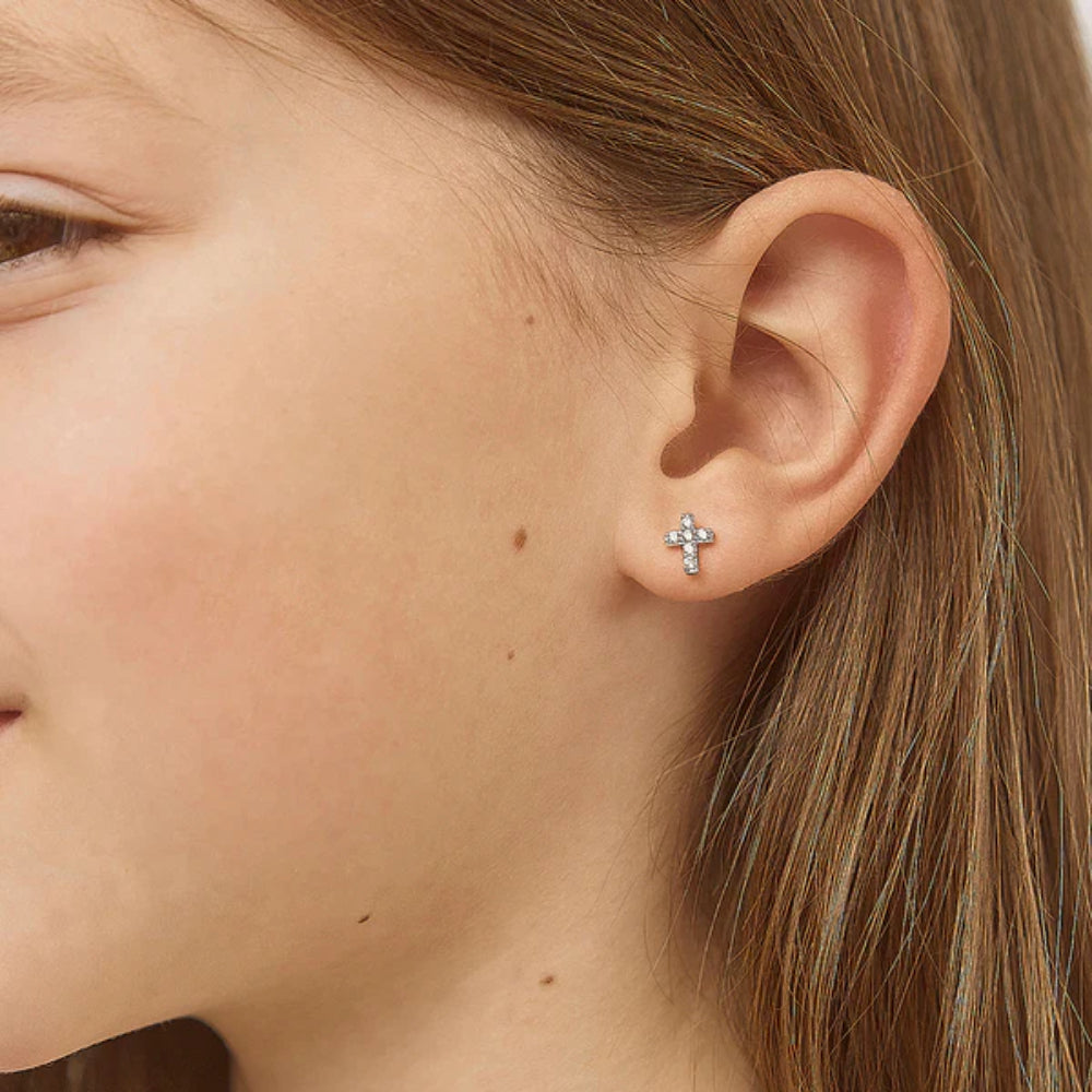 Close-up of an ear wearing a diamond stud earring with a blurred background