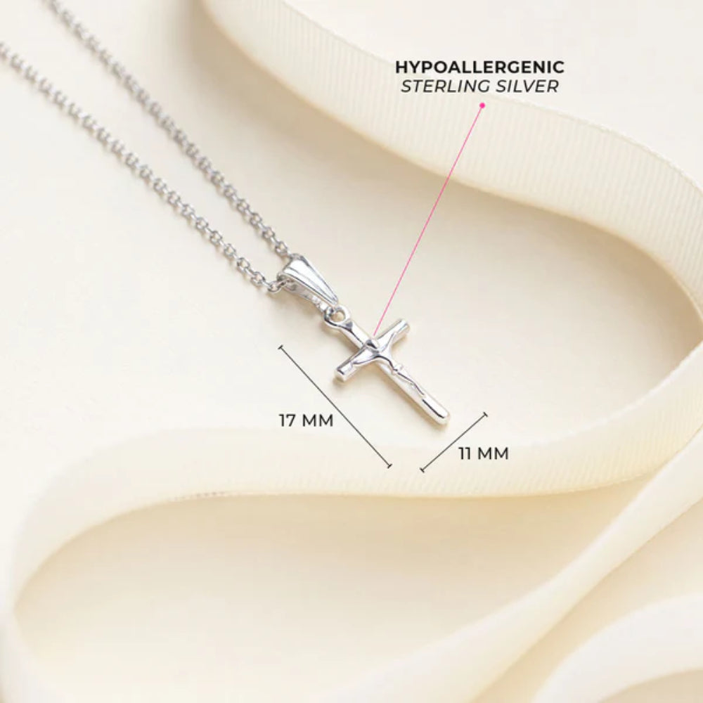Silver cross pendant necklace with measurements on a soft beige background