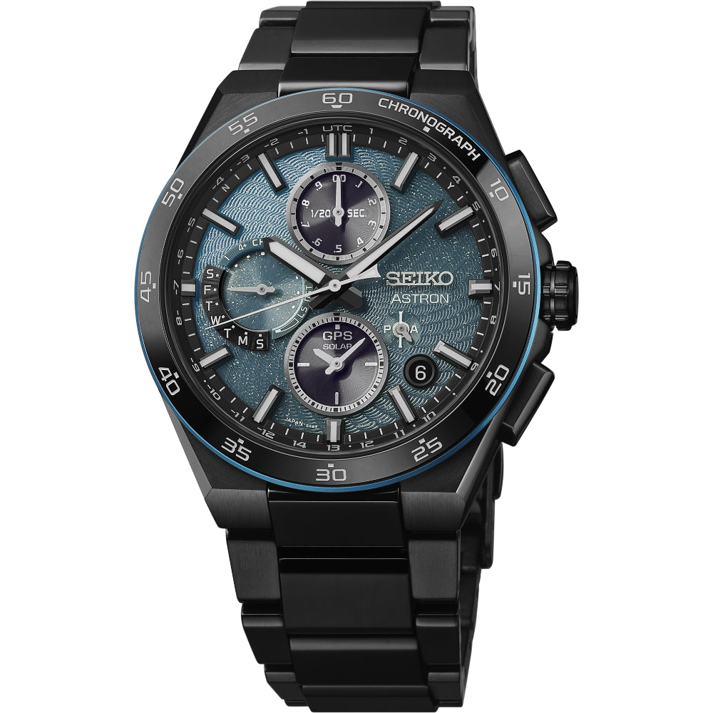 A Seiko Astron chronograph watch with a black stainless steel case and link bracelet, featuring a textured blue-gray dial with white and black subdials and a black bezel with blue accents.