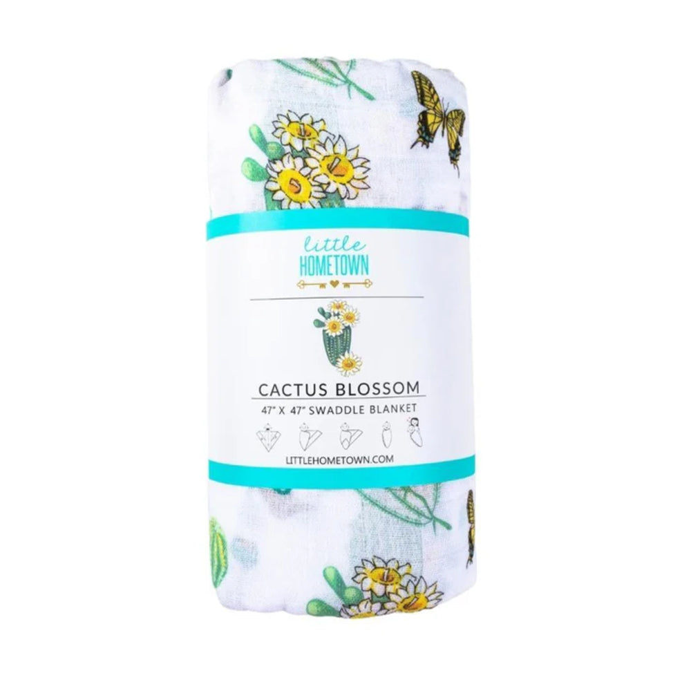 Cactus-themed swaddle blanket with branding on a white background