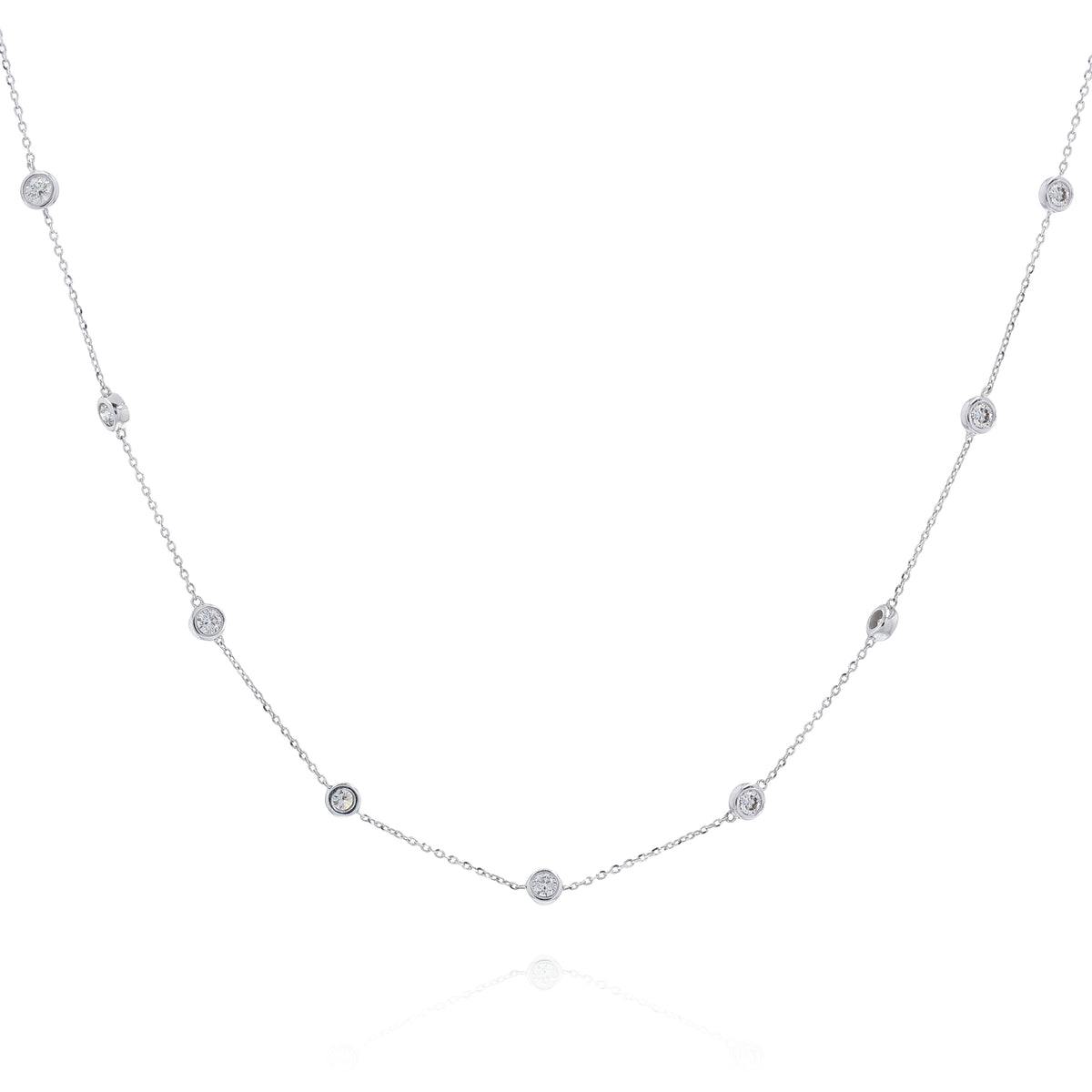 A delicate white gold chain necklace featuring multiple small, bezel-set round diamond stations displayed against a solid white background.