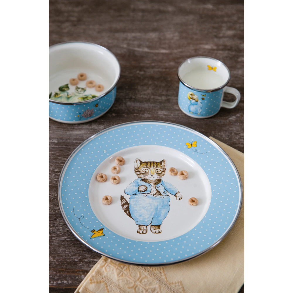 Children's 3-piece Tom Kitten enamelware set with  cup, plate and bowl on a brown table with tan napkin. 