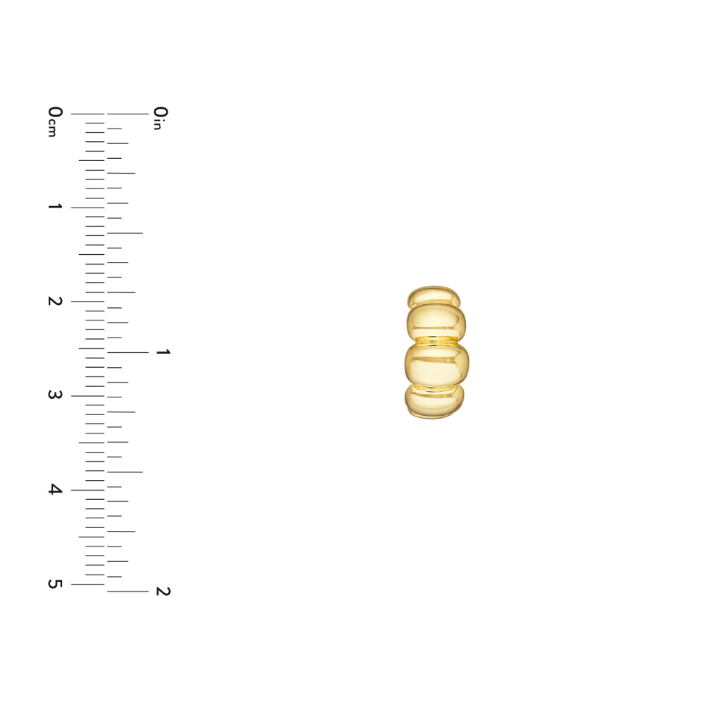 gold tone puffy hoop earring on white background next to scale