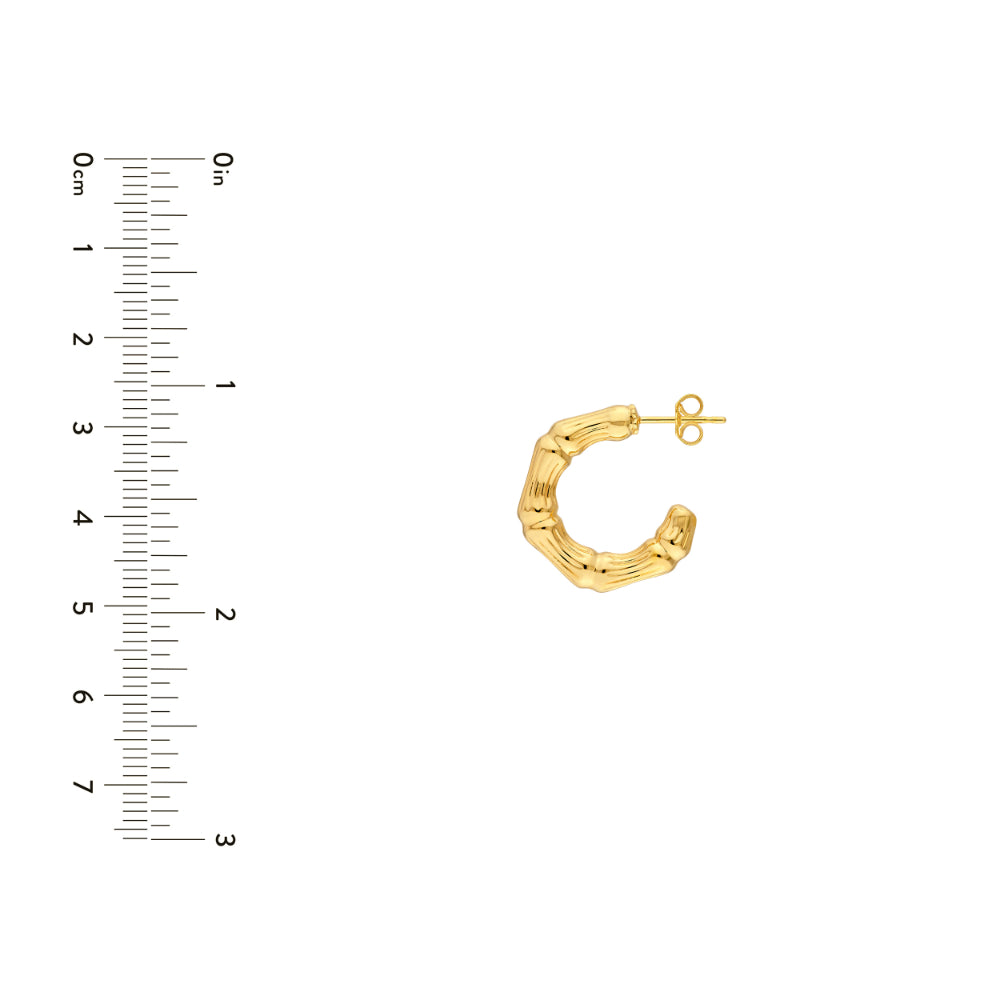 gold tone textured hoop earring on white background next to scale