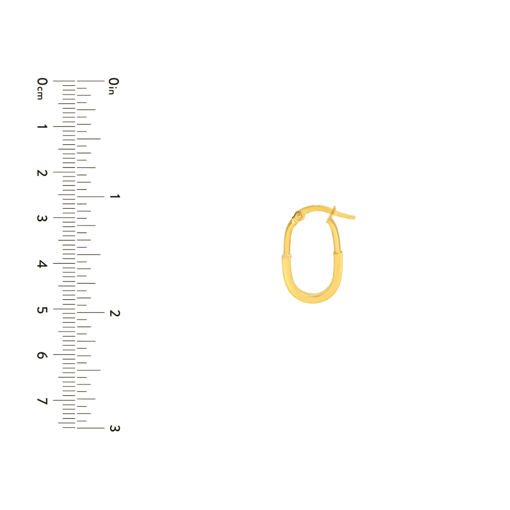 gold tone oval hoop earrings on white background next to scale