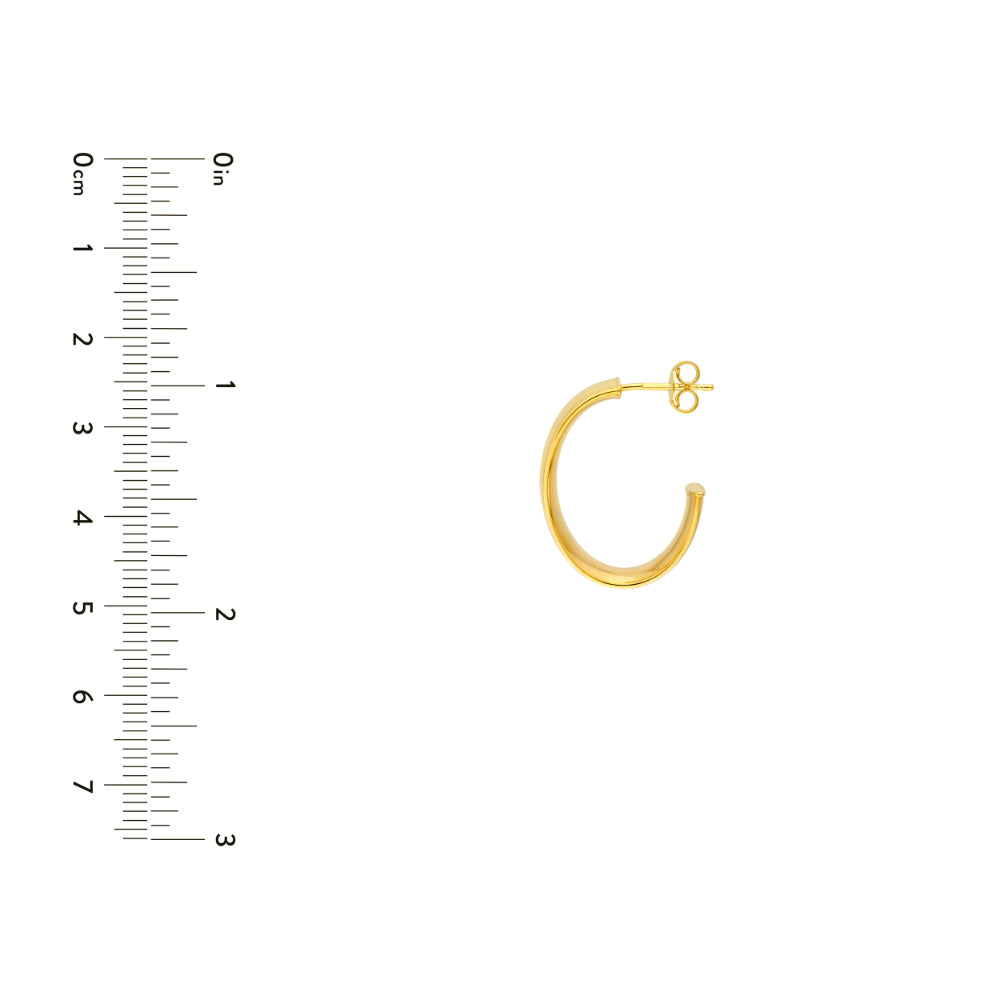 oval gold tone hoop earring on white background next to scale