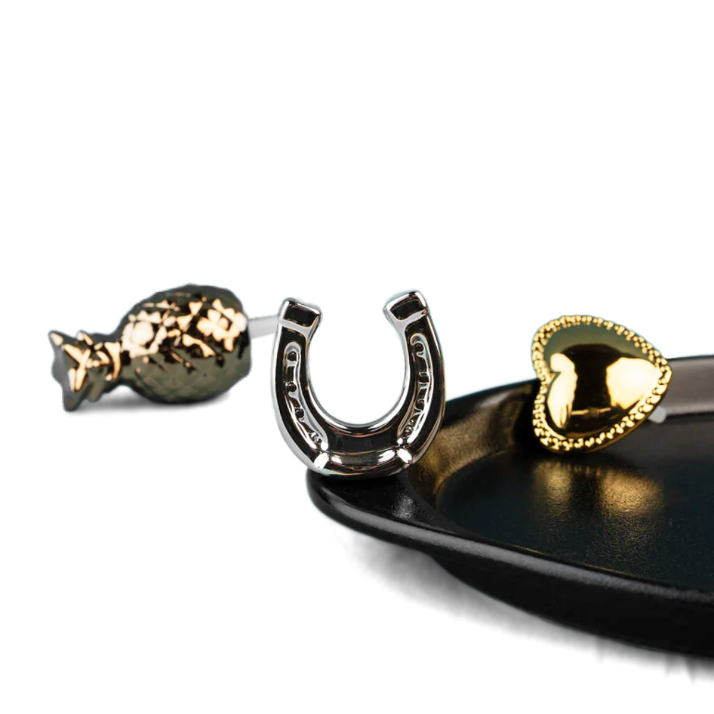 Decorative items including a gold fish, silver horseshoe, and gold heart on a black tray.