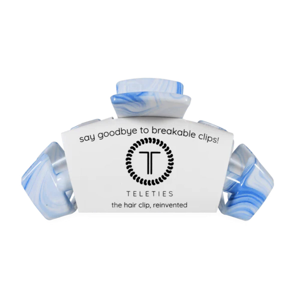 Hair clip with marbled blue and white design on a white background, featuring the brand 'Teleties'.