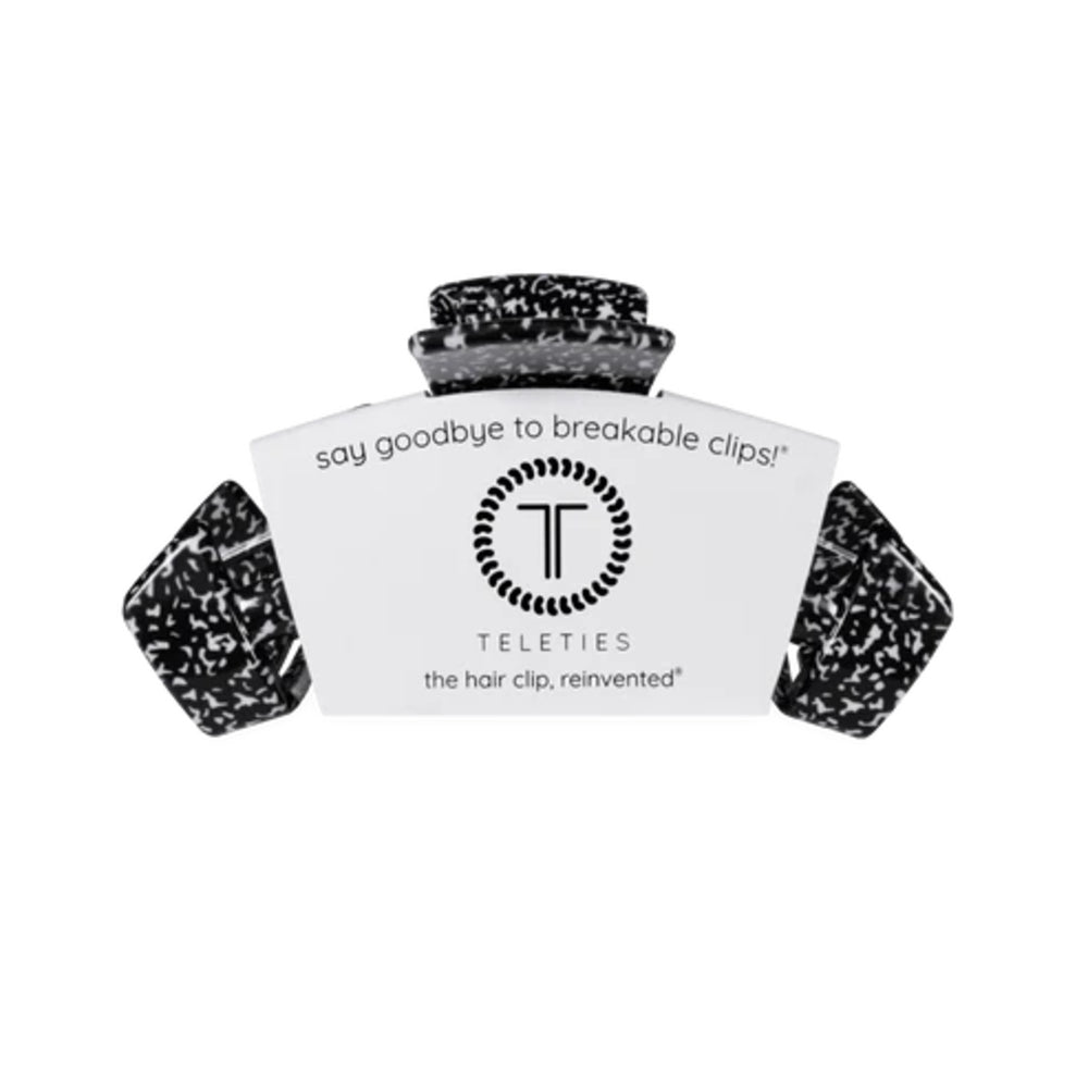 A Teleties hair clip in a black and white speckled material, shown with its white branded cardboard packaging on a plain white background.