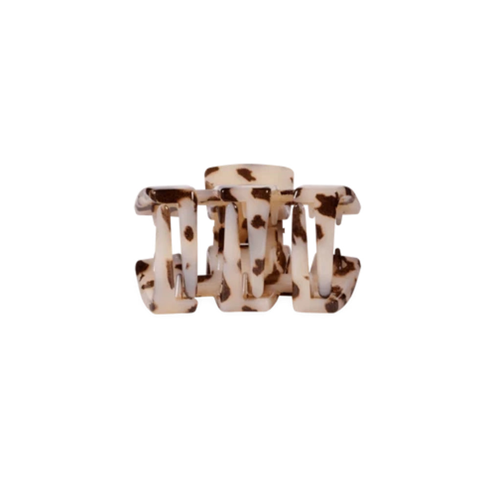 A tortoiseshell hair claw clip with a cream and brown mottled pattern, shown against a plain white background.