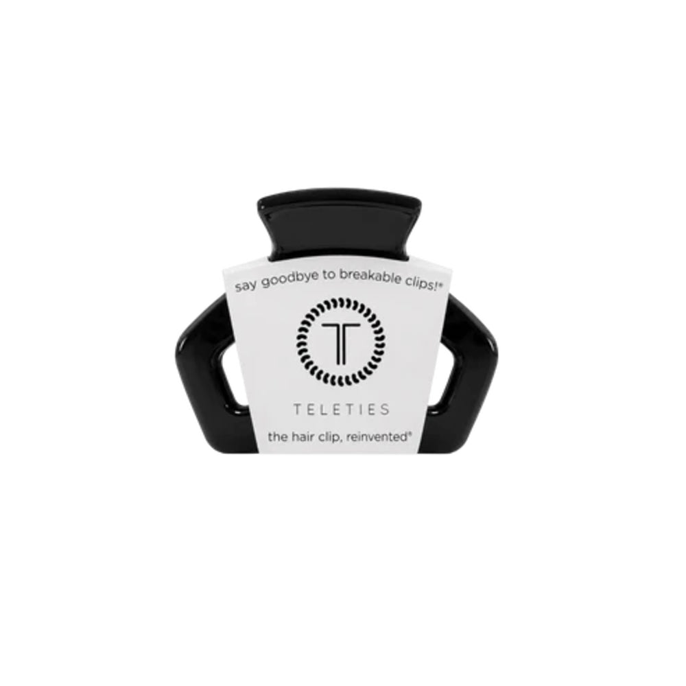 Black hair clip with a white label on a white background