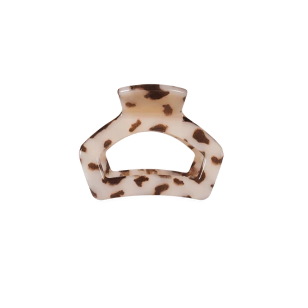 A tortoiseshell hair claw clip with a cream-colored base and dark brown spots, shown against a plain white background.