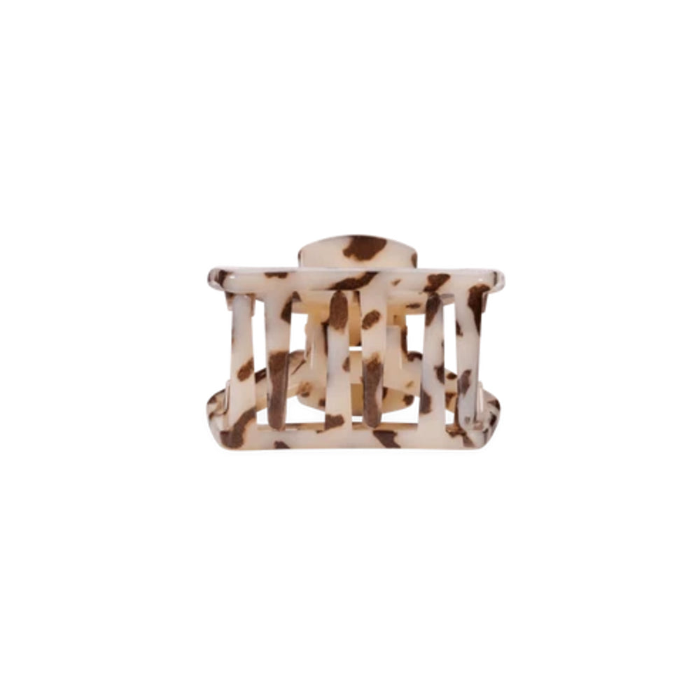A single hair claw clip with a tortoiseshell pattern in cream, brown, and beige, shown against a plain white background.