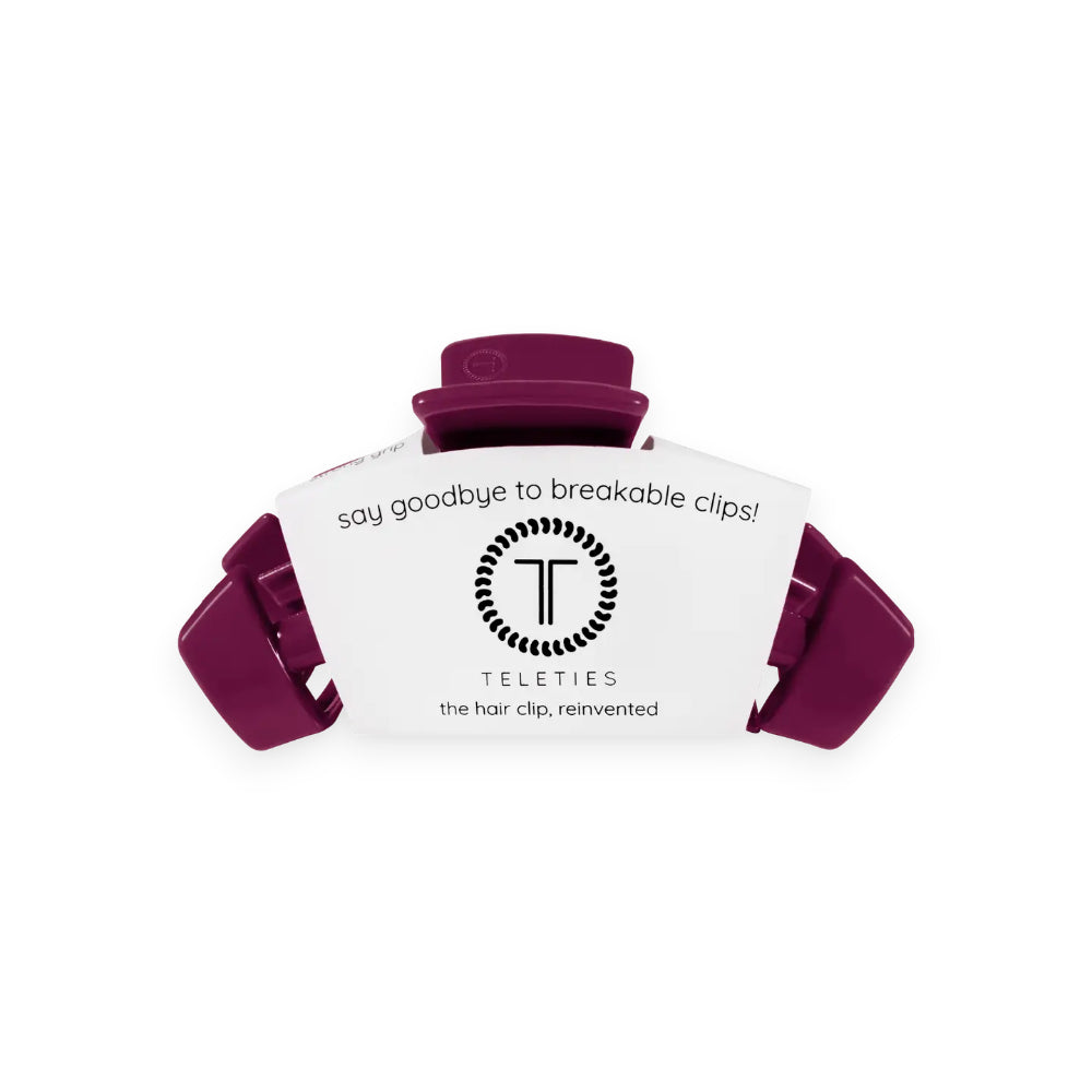 A purple hair claw clip with a white paper insert card displaying the brand TELETIES and slogan 'say goodbye to breakable clips!'.