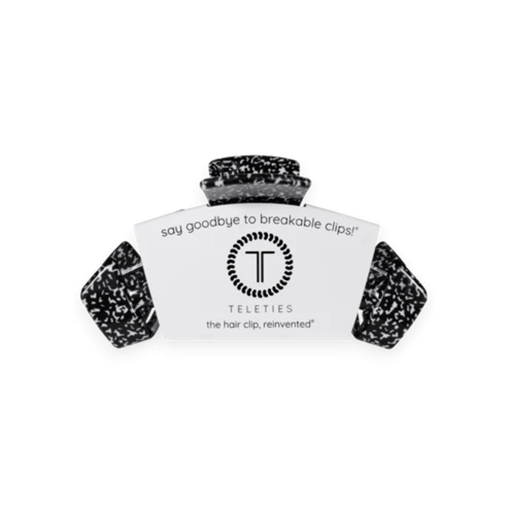 A Teleties hair clip in a black and white speckled resin finish, shown with its white cardboard packaging label on a plain white background.