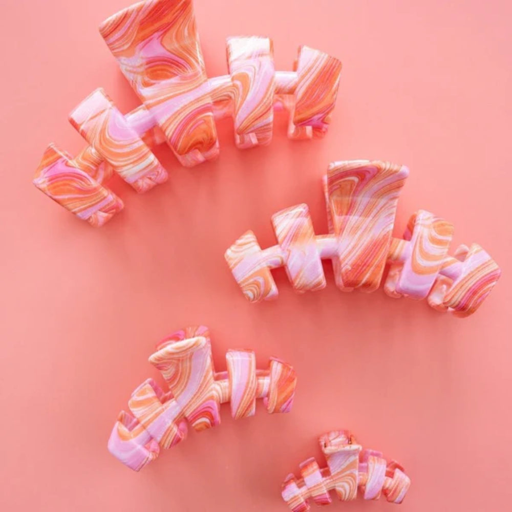 Marbled hair clips arranged on a pink background