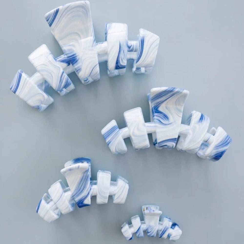 Marble-patterned hair clips on a gray background