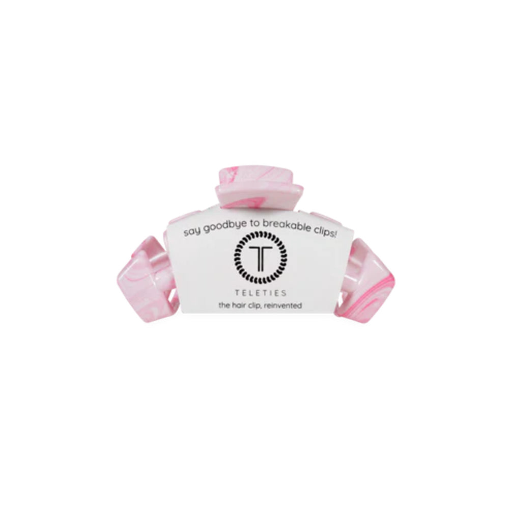 Pink hair clip with a white label on a white background