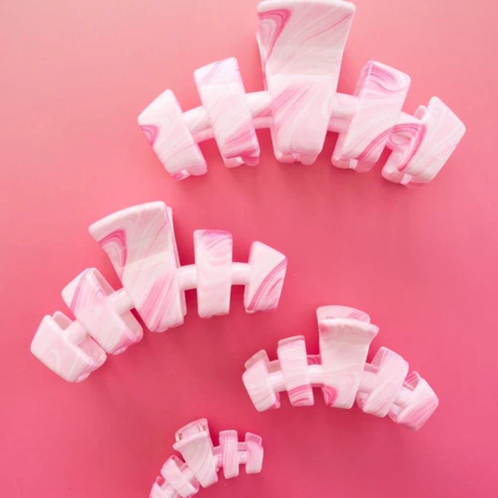 Set of pink and white hair clips on a pink background