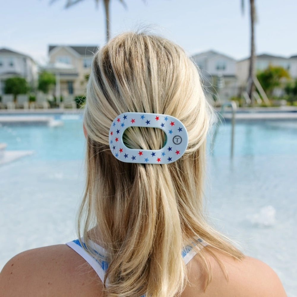 Person with a star-patterned hair clip by a pool