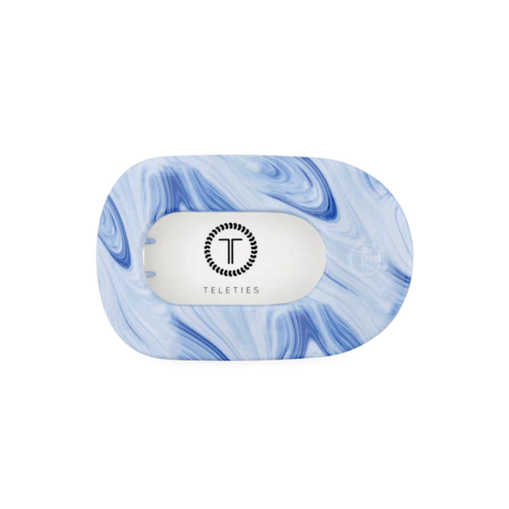 Blue and white marbled hair clip with 'Teleties' logo on a white background
