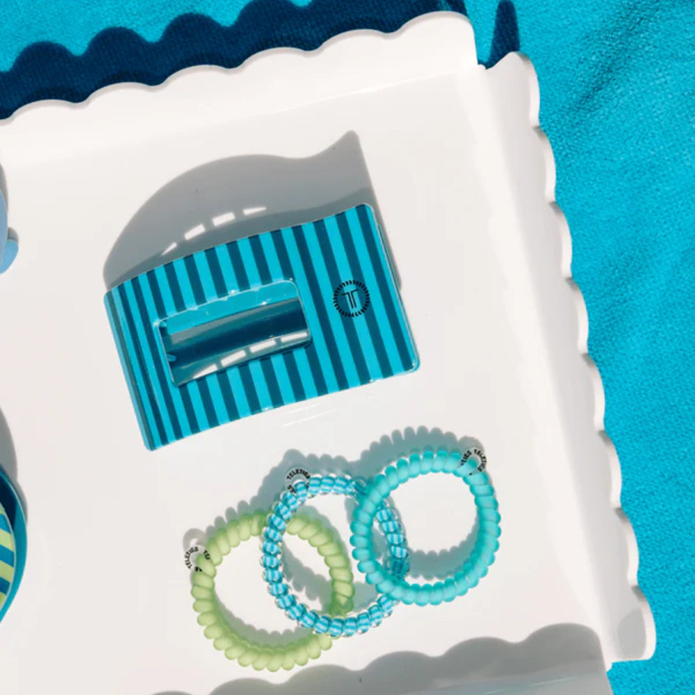 Blue hair tie maker with green and blue hair ties on a white background