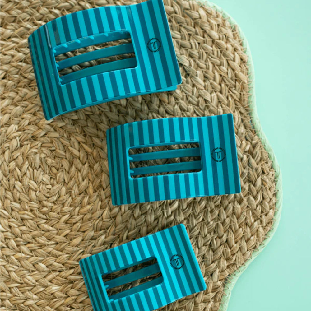 Three blue striped rectangular objects on a woven mat with a light green background