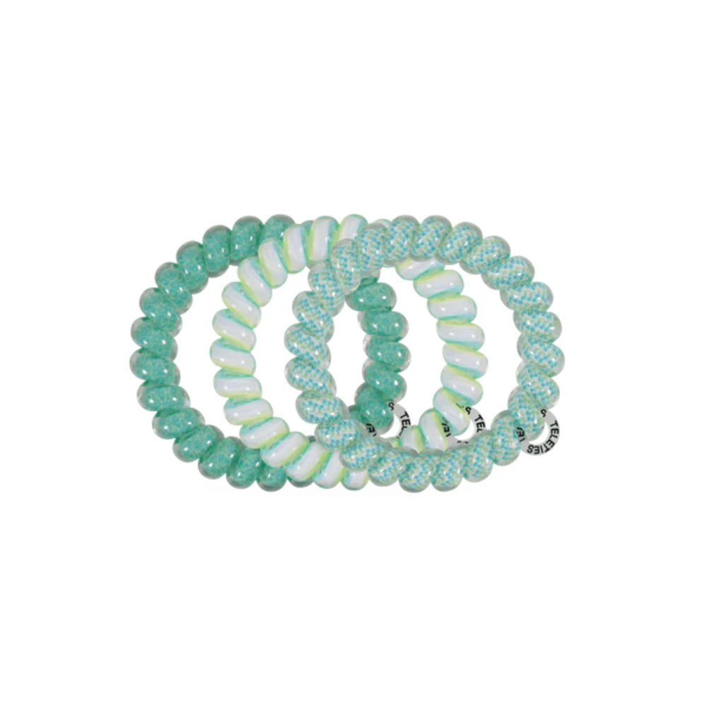 Set of green and white beaded hair ties on a white background