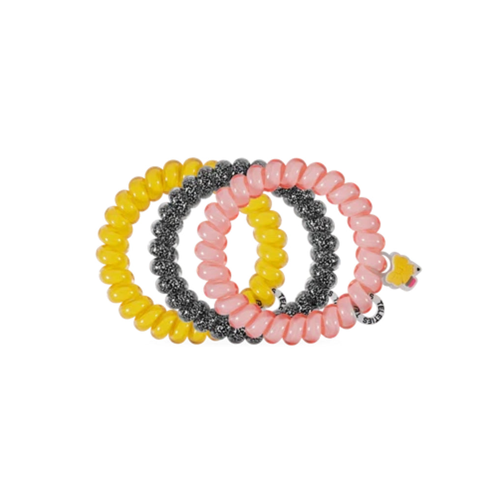 Three coiled beaded stretch bracelets in yellow, translucent pink, and metallic silver, with a small yellow flower charm on the pink bracelet, shown on a plain white background.