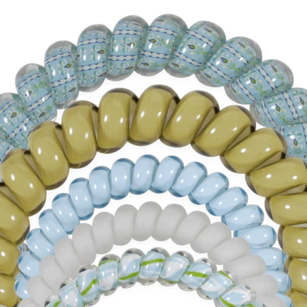 A close-up of multiple glass beaded bracelets arranged in overlapping rings on a white background. The bracelets feature glossy and matte finishes in pale blue, translucent aqua with green and white swirls, muted olive yellow, and frosted white.