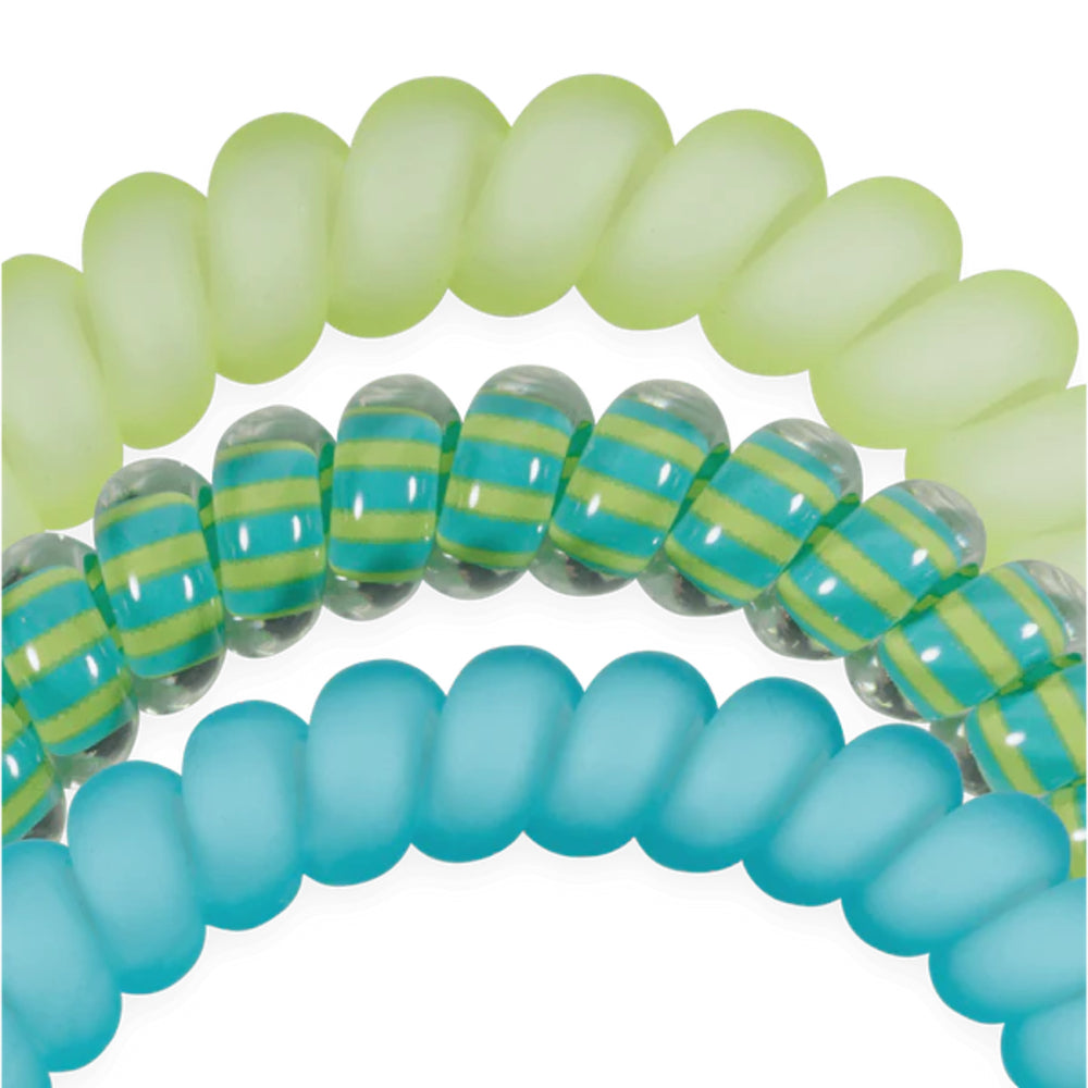 Close-up of green and blue spiral hair ties on a white background