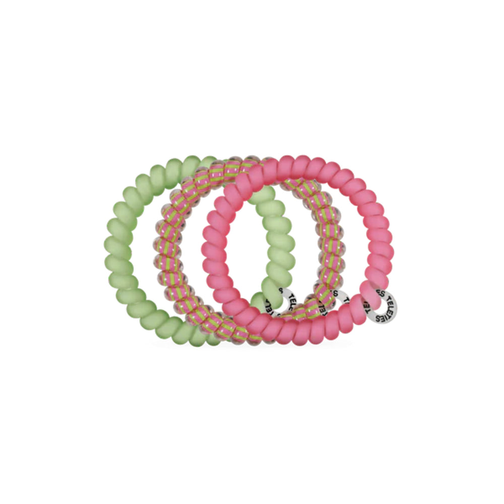 Set of pink and green hair ties on a white background