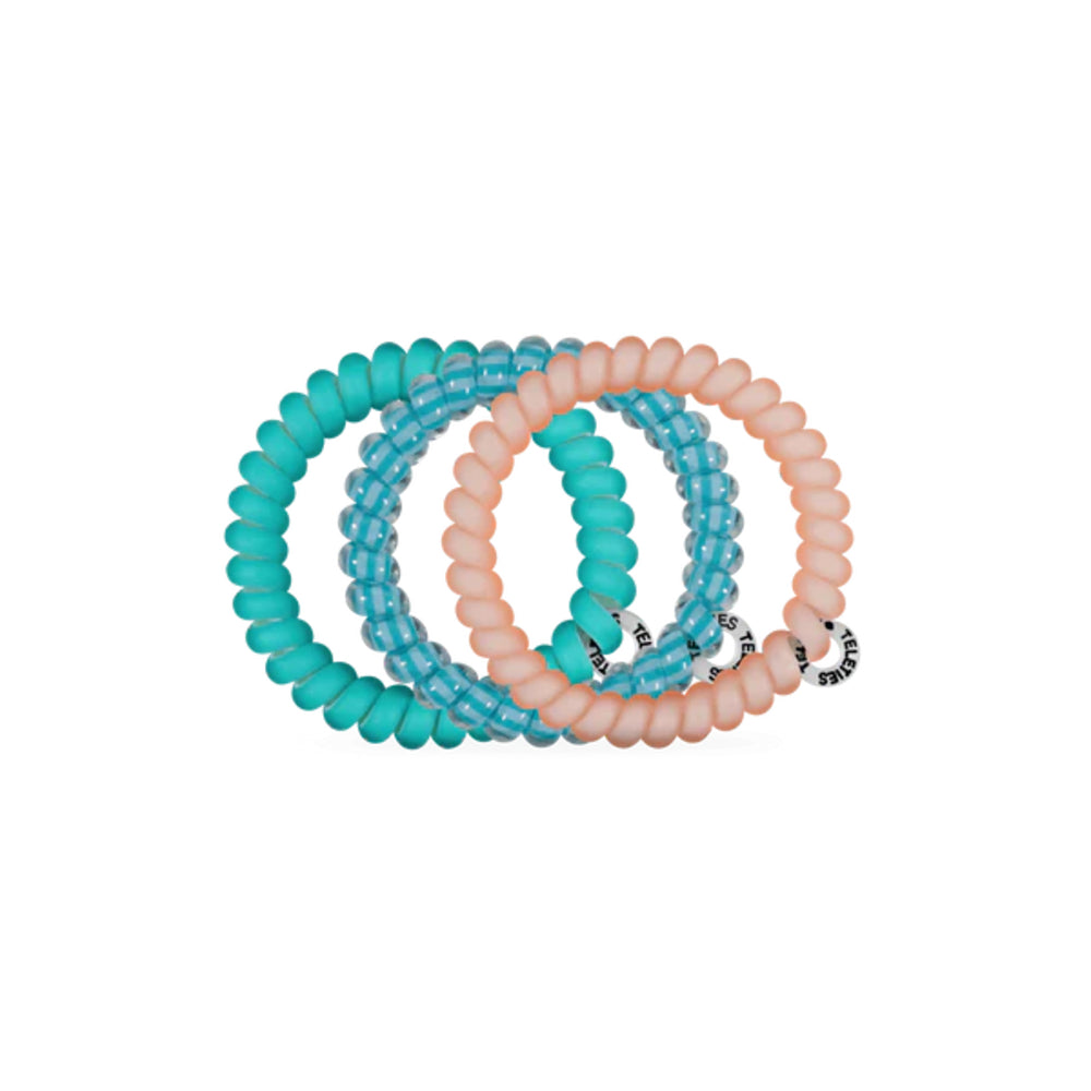 Set of turquoise and peach hair ties on a white background