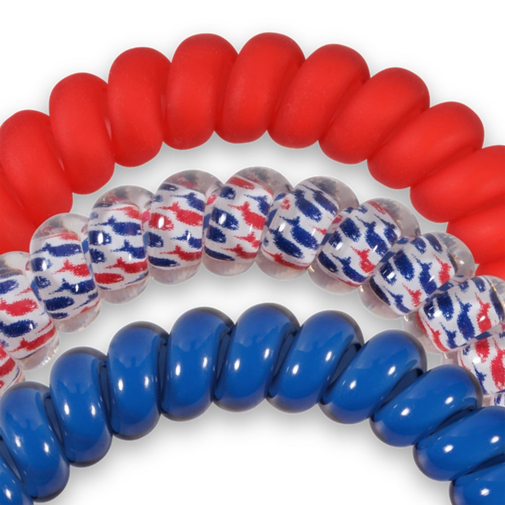 Coiled red, blue, and patterned hair ties on a white background