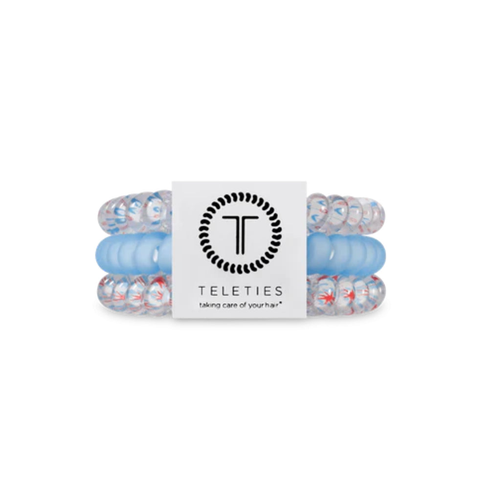 Set of blue and red hair ties with a Teleties branded card on a white background