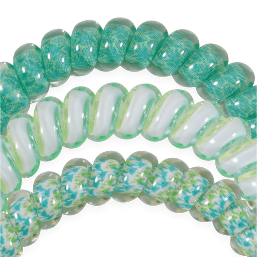 Close-up of green and white hair ties on a white background