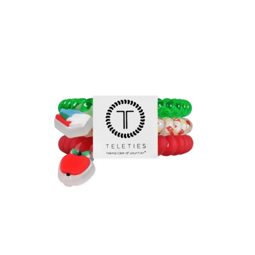 A Teleties hair care set featuring multiple colorful silicone hair ties and a white central card with the Teleties logo and 'hair care of your hair' text, shown on a plain white background.