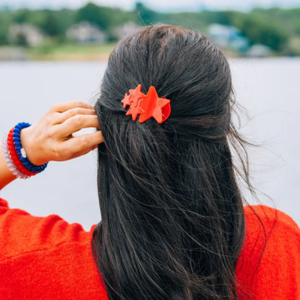 Person with red hair clip by a body of water