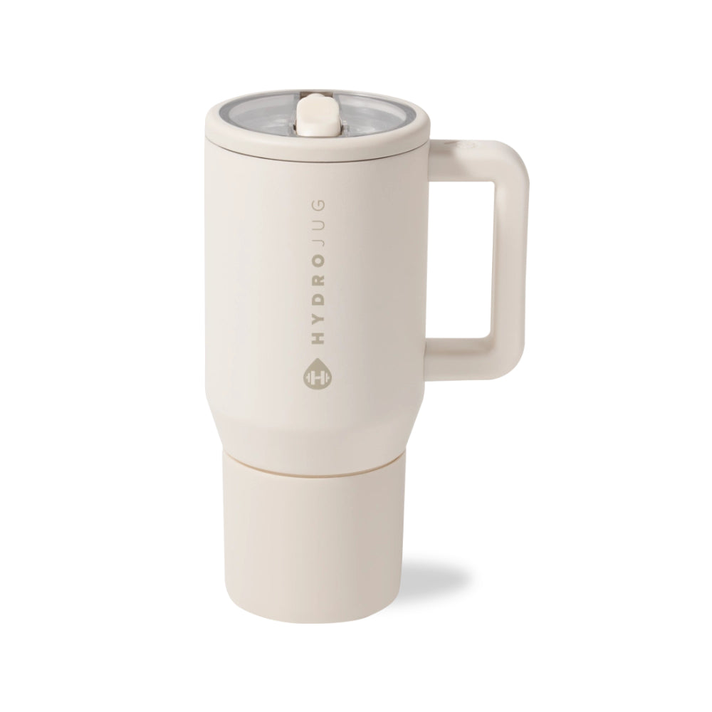 A HydroJug travel tumbler in a warm cream or off-white color, featuring a handle, a clear lid with a white straw, and a separate cup attachment at the bottom. The HydroJug brand name is printed vertically on the side.