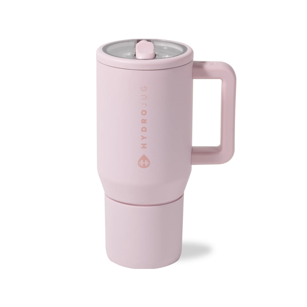 A light pink HydroJug travel mug with a handle, shown on a clean white background. The mug features a matching pink lid with a clear rim and a separate bottom cup attachment.