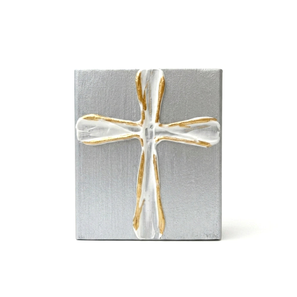 Decorative silver wood block with a gold and white cross on a white background