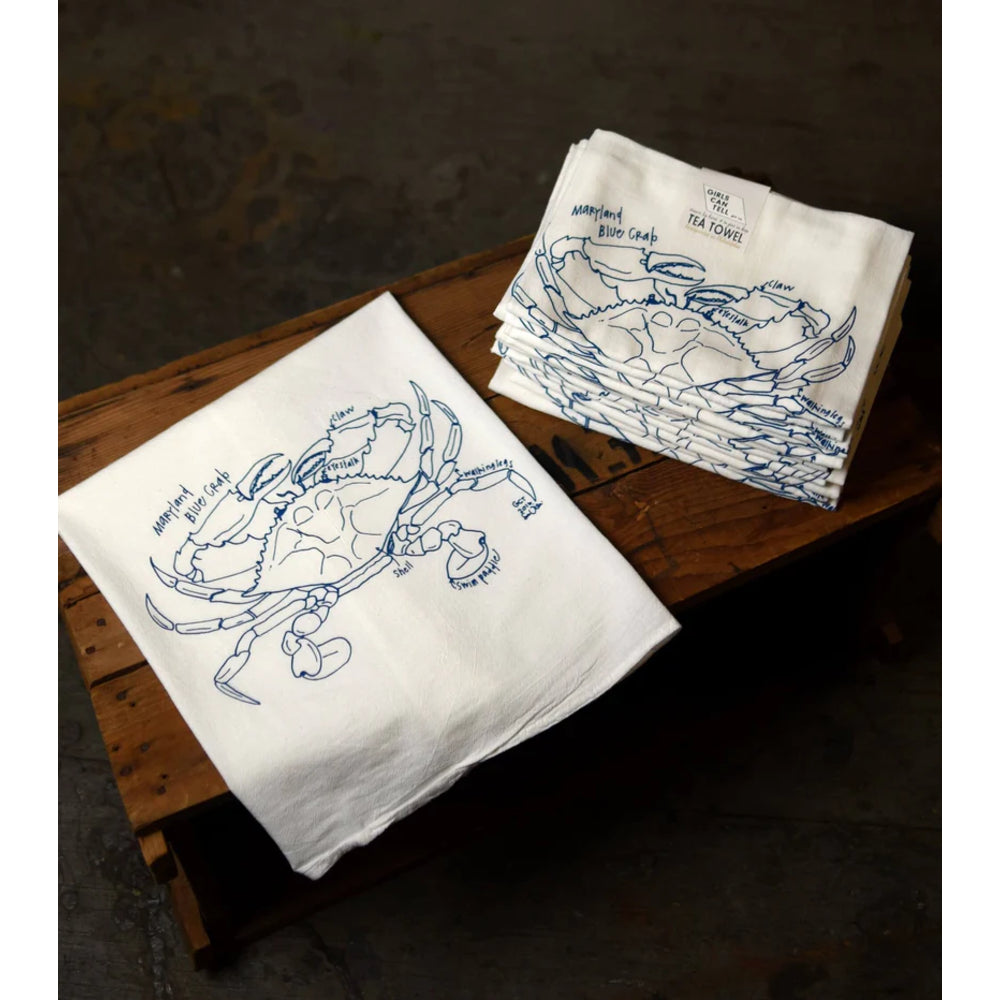 White towels with blue crab design on a wooden surface