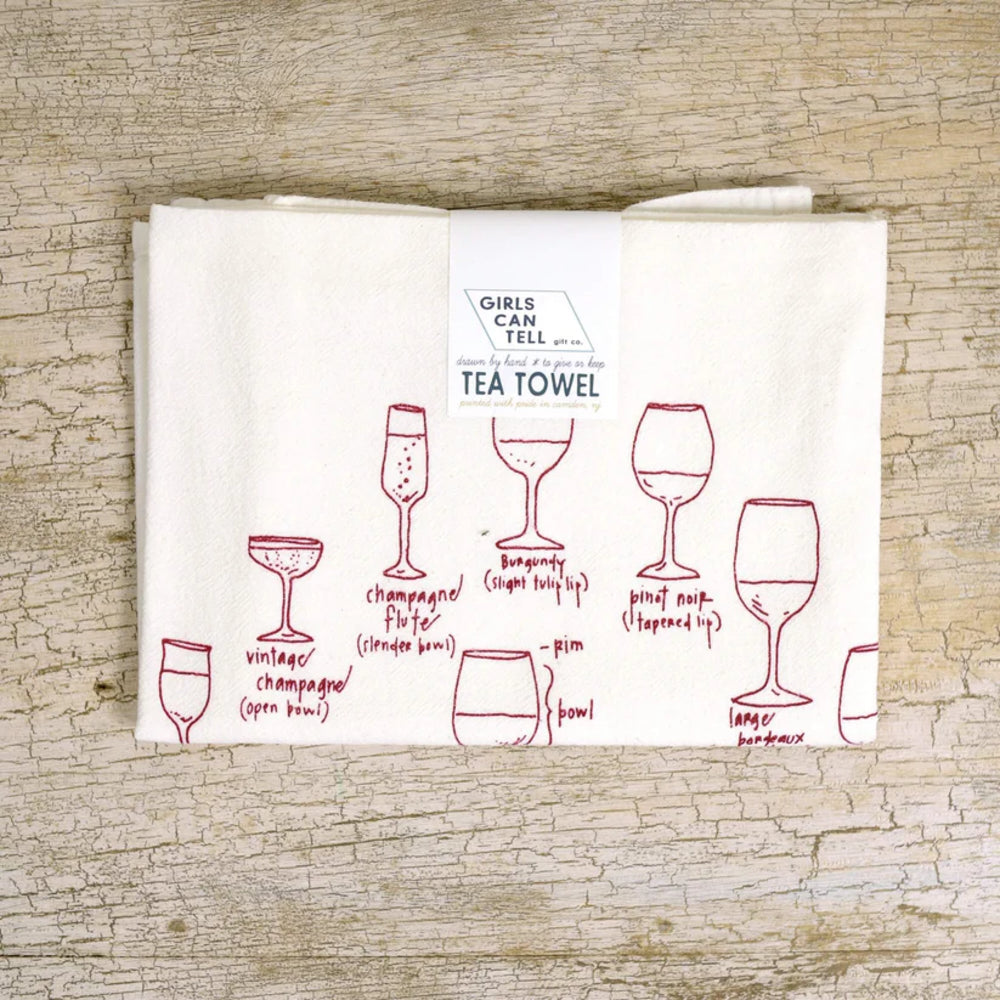 Tea towel with wine glass illustrations on a wooden surface