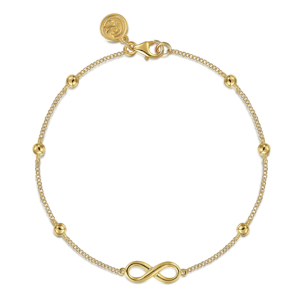 gold infinity symbol bracelet on a white background