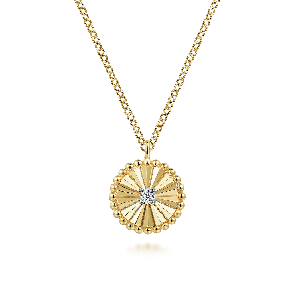 Gold necklace with a round pendant featuring a diamond on a white background